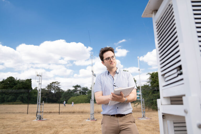 University of Reading researches how to create weather forecasts one month in advance A researcher notes down readings from a weather station, in front of a blue sky.