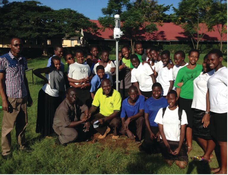 CASE STUDY: Trans-African Hydro-Meteorological Observatory A group of adults and school children gather around a weather measurement station.