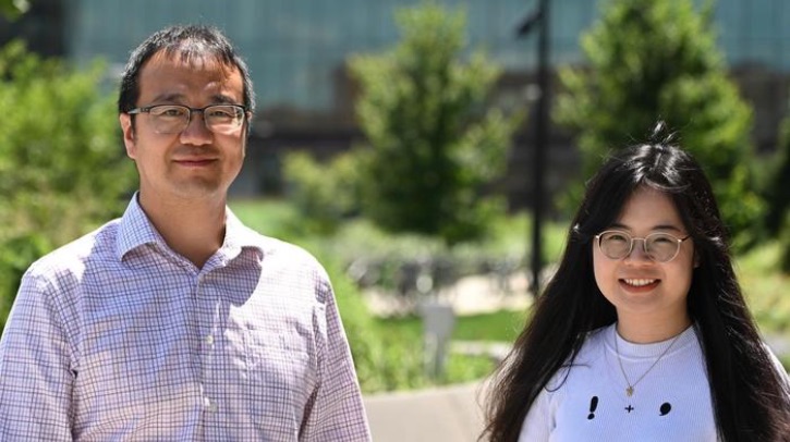 Researchers develop AI-powered computational model to improve US flood predictions Two researchers smile into the camera against a garden backdrop.