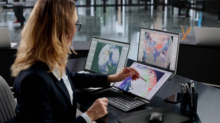 FEATURE: Turning forecast verification into a public benchmark A lady sits at a bank of computer screens in an office. She is wearing a dark suit jacket and a white shirt.